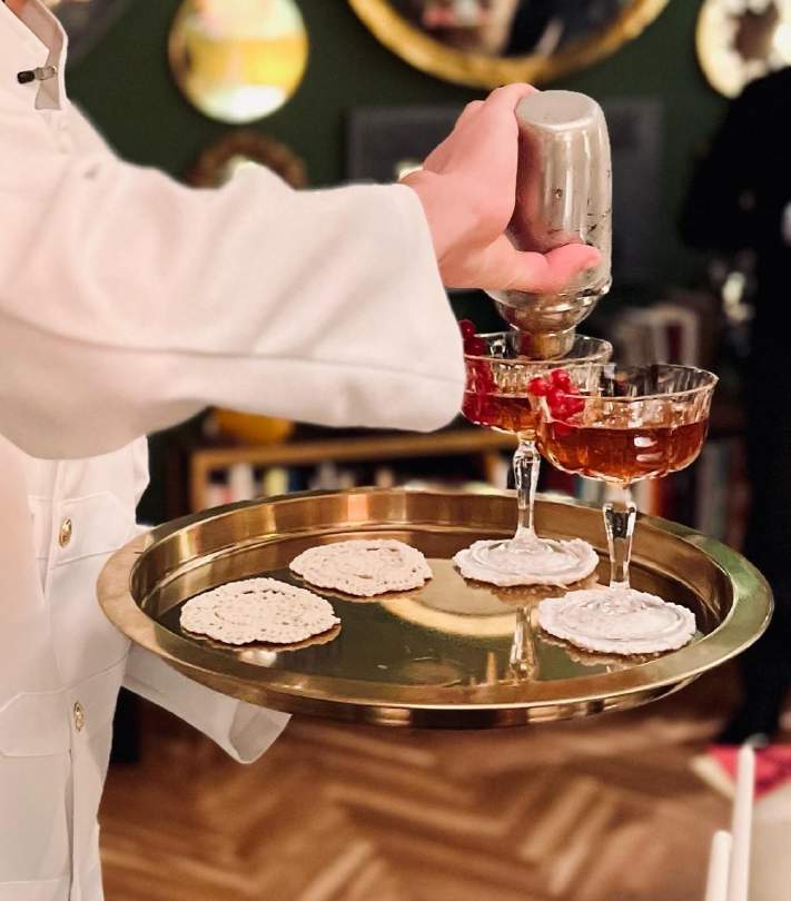 Il personale Drink & Taste prepara un cocktail su un vassoio dorato